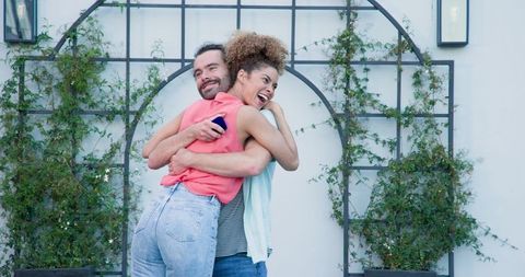 Romantic Garden Proposal with Joyful Interracial Couple Embracing