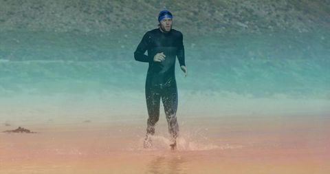 Athlete emerging from lake wearing wetsuit during training