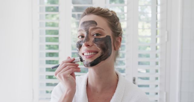 Smiling Woman Applying Facial Mask with Brush at Home - Download Free Stock Images Pikwizard.com