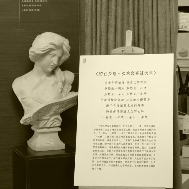 Classical bust sculpture next to framed poem display in sepia tone. Suitable for museum exhibits, cultural heritage promotions, literature appreciation, and artistic decoration themes.