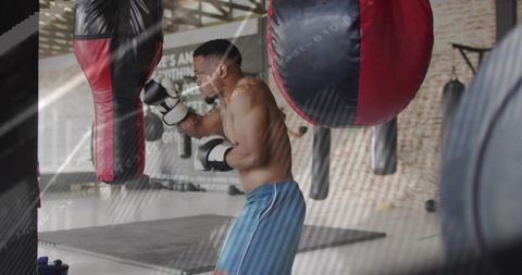 Boxer Training in Gym with Punching Bag Focused on Fitness