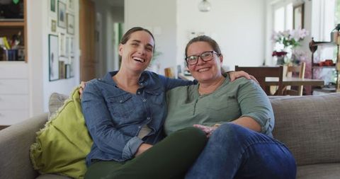 Happy Caucasian Lesbian Couple Relaxing on Sofa at Home
