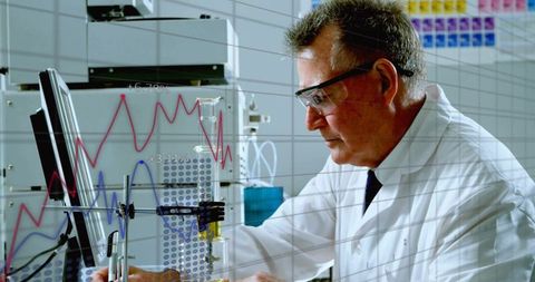 Senior scientist monitoring chromatography data on computer in analytical laboratory