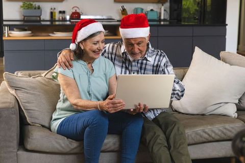 Senior Couple Celebrating Christmas With Laptop at Home