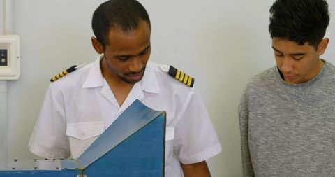 Pilot mentoring teen explaining aircraft mechanics