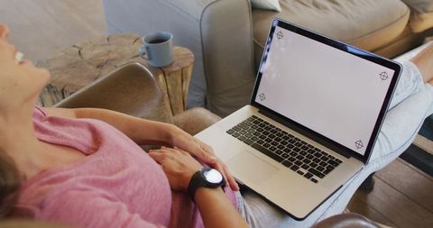 Pregnant Woman Relaxing with Laptop in Cozy Home Environment