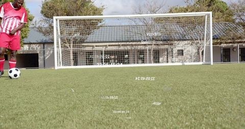 Male Soccer Player Standing on Artificial Turf Preparing Kick toward Goal with Clubhouse Background