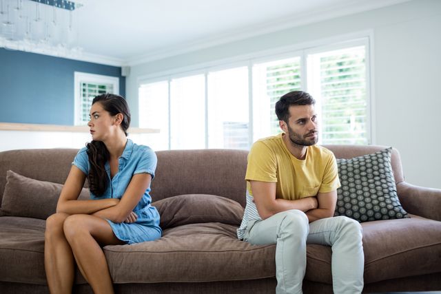 Couple ignoring each other in the living room at home