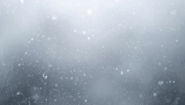 Falling snowflakes and soft mist bokeh creating serene winter background texture