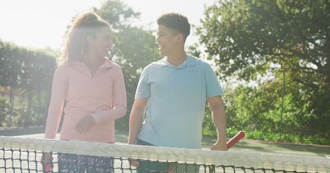 Happy Couple Enjoying Tennis Outdoors in Sunlight