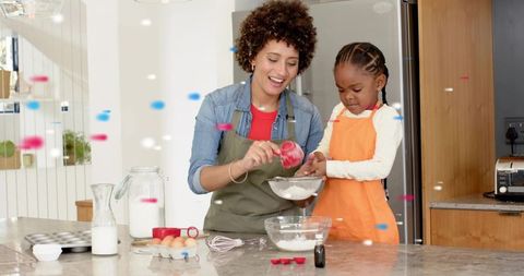 Parent and child baking together on kitchen island sifting flour and measuring ingredients