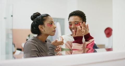 Diverse Friends Applying Hydrogel Eye Patches at Beauty Studio