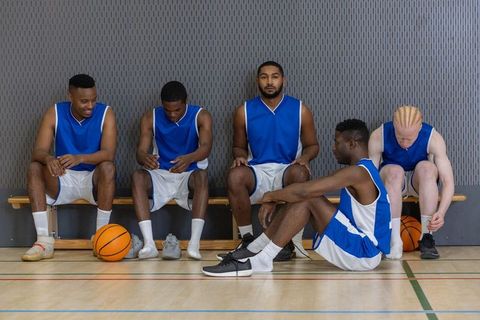 Diverse male teammates preparing for basketball game