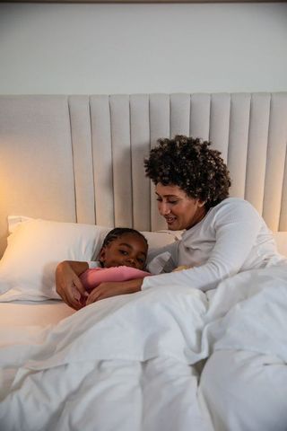 Mother and Daughter Cuddling in Cozy Bedroom