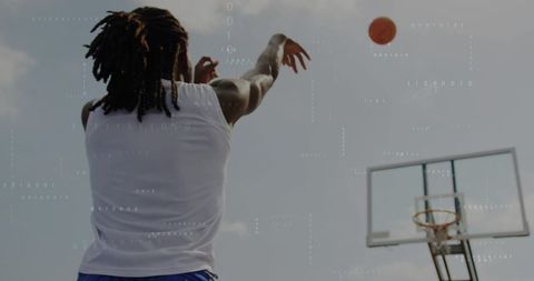 Athlete shooting jump shot on outdoor basketball court, ball arcing toward hoop