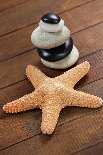 Stacked Pebble Stones and Starfish on Wooden Surface - Download Free Stock Photos Pikwizard.com