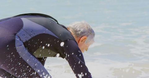 Senior Surfer Embracing Ocean Waves in Tranquil Beach Scene