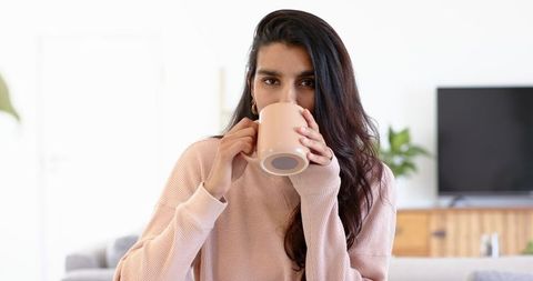 Young Woman Relaxing with Ceramic Mug in Cozy Modern Living Room