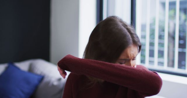 Young Woman Sneezing into Elbow in Living Room - Download Free Stock Images Pikwizard.com