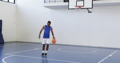 Basketball Player Dribbling on Indoor Court Focused on Practice