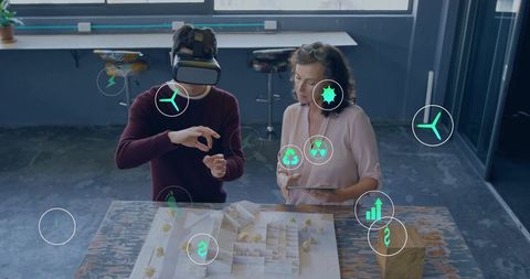 Designers using vr and tablet over architectural model with ar sustainability icons