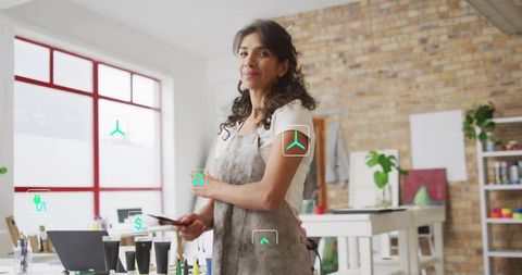 Confident mature artist holding smartphone in creative studio