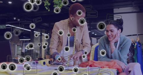 Fashion designers collaborating in trendy studio with orange fabric