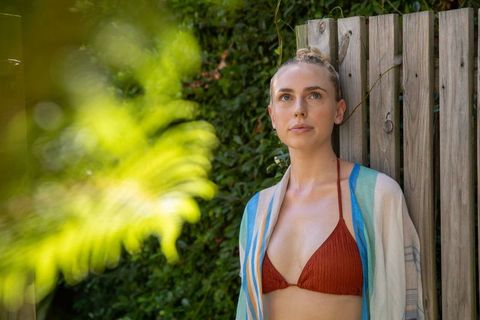 Stylish woman posing in natural garden setting engaging with nature