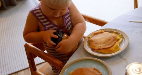 Toddler Enjoying Pancakes at Breakfast Table