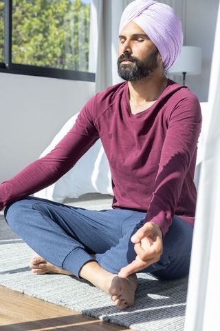 Turbaned Man Achieving Serenity at Home with Meditation