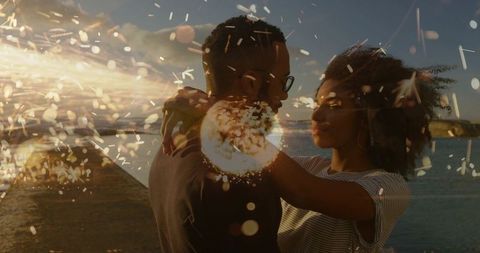 Romantic couple embracing on pier at sunset with spark bokeh double exposure cinematic