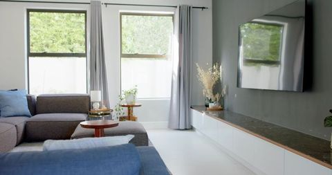 Minimalist contemporary living room with l-shaped gray sectional sofa and blue accents