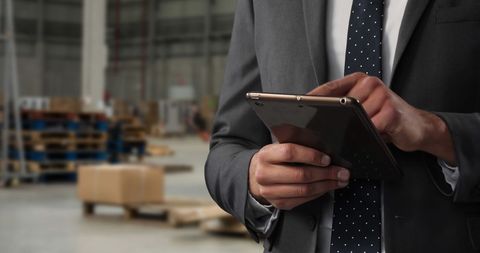 Businessman Using Digital Tablet in Warehouse