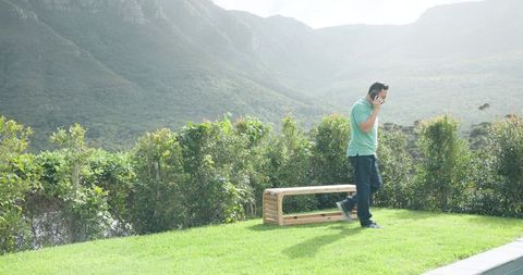 Man Walking in Serene Outdoors Talking on Smartphone
