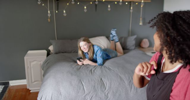 Friends Relaxing on a Bed with Smartphone in Cozy Bedroom - Download Free Stock Images Pikwizard.com