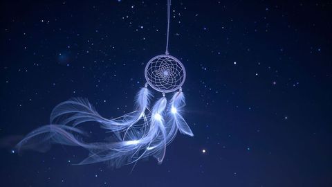 Celestial dreamcatcher hanging against starry night sky