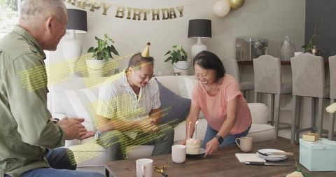 Family celebrating birthday with cake, candles, balloons and gifts