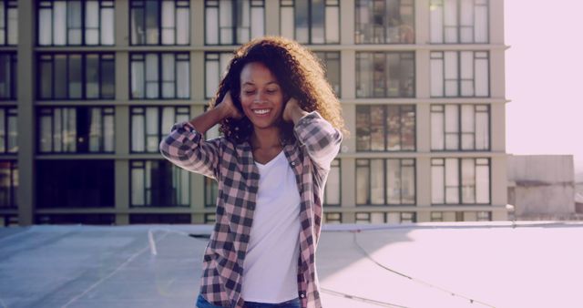 Young woman enjoying rooftop sunshine in casual attire - Download Free Stock Images Pikwizard.com