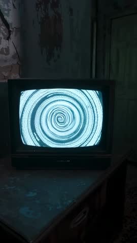 CRT TV Showing Expanding Spiral Vortex on Static Screen in Abandoned Room Vertical Video