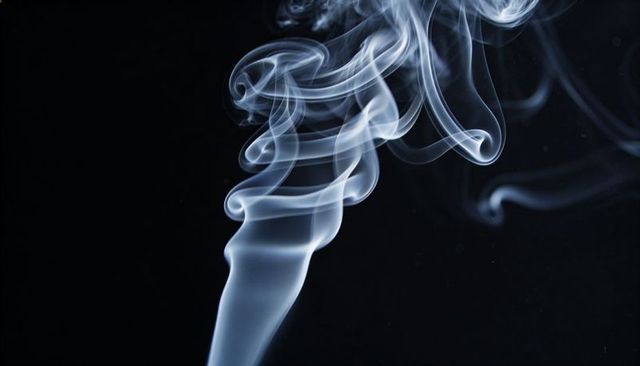 Rising Translucent Blue-White Smoke Twisting into Abstract Ribbon Spiral against Black