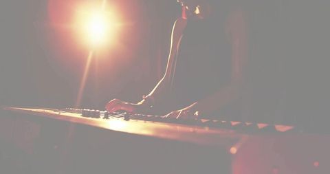 Female musician performing on stage with electric keyboard