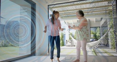 Mother and daughter sharing smartphone while dancing on home step with smart hud overlay