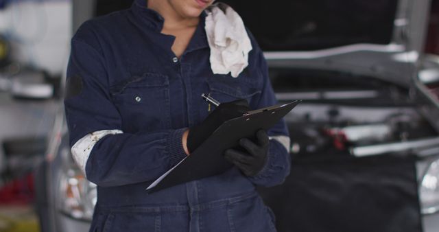 Female Mechanic Inspecting Car and Writing Maintenance Report - Download Free Stock Images Pikwizard.com