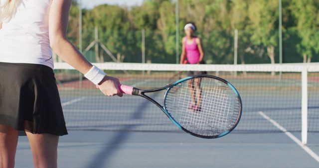 Image of midsection of caucasian female tennis player training with friend. professional tennis training, sport and competition concept.