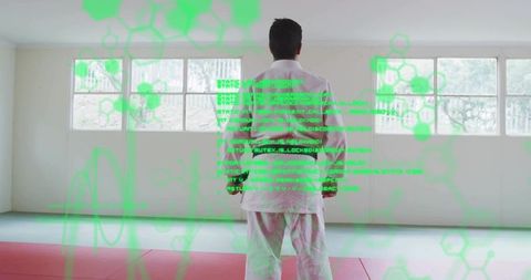 Martial artist training in gi with futuristic green holographic code overlay