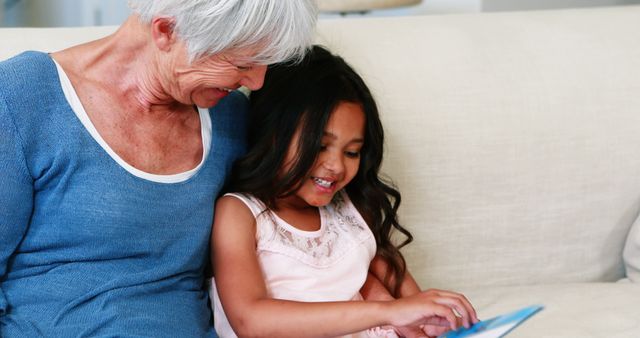 Smiling Grandmother and Granddaughter Reading Together - Download Free Stock Images Pikwizard.com