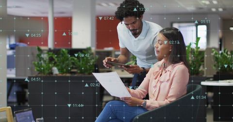 Colleagues Analyzing Business Reports in Modern Office