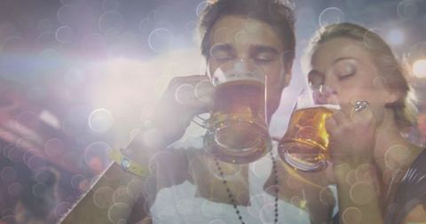 Friends Enjoy Nightlife in Festival Atmosphere with Beer Mugs