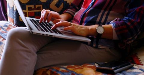 Midsection of Woman Relaxing at Home Using Laptop and Smartphone