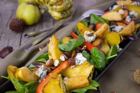 Showcasing roasted autumn squash and spinach salad with blue cheese, nuts, and peppers